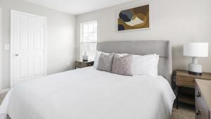 um quarto branco com uma cama branca e um candeeiro em Landing Modern Apartment with Amazing Amenities (ID1263X661) em New Albany