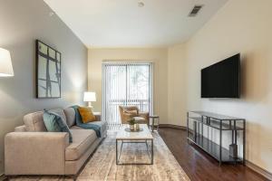 sala de estar con sofá y TV en Landing Modern Apartment with Amazing Amenities (ID1649X92) en Houston
