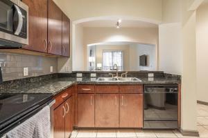een grote keuken met een wastafel en een magnetron bij Landing Modern Apartment with Amazing Amenities (ID1649X92) in Houston