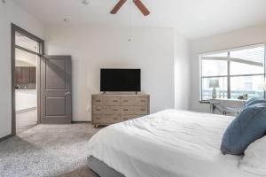 een slaapkamer met een bed en een flatscreen-tv bij Landing Modern Apartment with Amazing Amenities (ID1649X92) in Houston