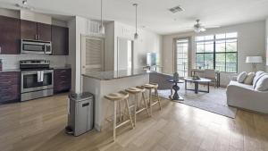 a kitchen and living room with a counter and stools at Landing Modern Apartment with Amazing Amenities (ID9660X22) in Orlando