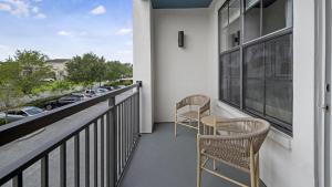 a balcony with two chairs and a view of a street at Landing Modern Apartment with Amazing Amenities (ID9660X22) in Orlando