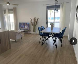 a dining room with a table and blue chairs at Clauadris Home ideal para familias in Águilas