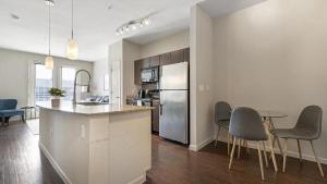 cocina con nevera, mesa y sillas en Landing Modern Apartment with Amazing Amenities (ID4179X58), en Austin
