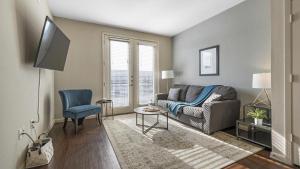 ein Wohnzimmer mit einem Sofa und einem TV in der Unterkunft Landing Modern Apartment with Amazing Amenities (ID4179X58) in Austin