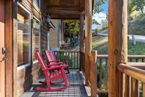 duas cadeiras vermelhas sentadas no alpendre de uma cabana em Deer Valley em Branson