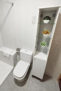 a white bathroom with a toilet and shelves at CASA RURAL CELIA con Escape Room y desayuno in Ayna +25 photos