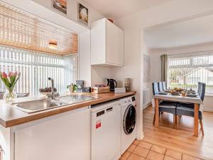 uma cozinha com um lavatório e uma máquina de lavar roupa em 3 Bed in Heacham 84044 em Heacham