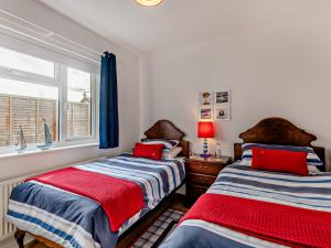 um quarto com 2 camas e uma janela em 3 Bed in Heacham 84044 em Heacham