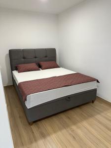 a bed in a room with a white wall at Apartment First Row in Komarna