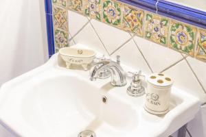 - un lavabo blanc dans la salle de bains avec une tasse dans l'établissement Villa Zaffiro, à Pollina