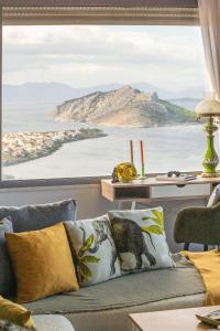 a living room with a couch and a large window at La Casa Del Sol Villa in Aegenitissa