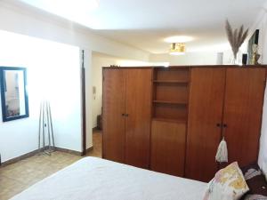 a bedroom with a wooden cabinet and a bed at Barrio Norte hermoso apart privado in San Miguel de Tucumán