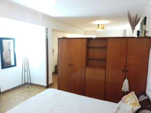 1 dormitorio con armario de madera y cama en Barrio Norte hermoso apart privado en San Miguel de Tucumán