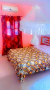 ein Schlafzimmer mit einem Bett mit einer bunten Bettdecke in der Unterkunft Hotel evasion peche in Fimela