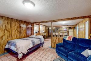 a bedroom with a bed and a blue couch at The Crown of Maine on Main in Madawaska