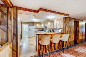 eine Küche mit Holzwänden und eine Bar mit Hockern in der Unterkunft The Crown of Maine on Main in Madawaska
