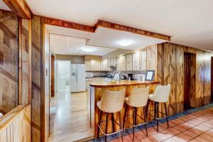 a kitchen with wooden walls and a bar with stools at The Crown of Maine on Main in Madawaska