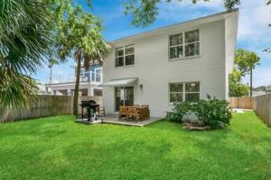 a white house with a grill in a yard at Casa Comares, Overlooks Lighthouse, Near DT + Bch! in Saint Augustine