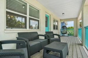 a living room with a couch and chairs on a porch at Casa Comares, Overlooks Lighthouse, Near DT + Bch! in Saint Augustine