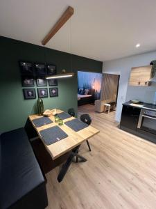 een woonkamer met een houten tafel en een keuken bij City Apartment Baden-Baden in Baden-Baden