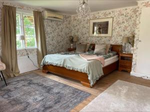 a bedroom with a bed and a chandelier at Bagarstugan in Kolbäck