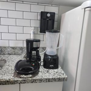 a blender sitting on a counter next to a refrigerator at Flat Premiere in Rio de Janeiro