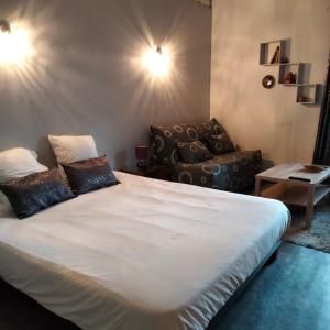 een slaapkamer met een groot wit bed en een stoel bij le jack in Mont-sous-Vaudrey