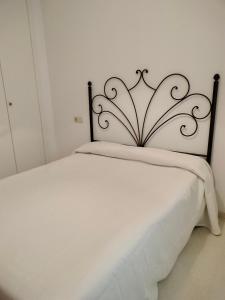 a white bed with a metal headboard in a room at El mirador de la Ría in Isla Cristina +16 photos