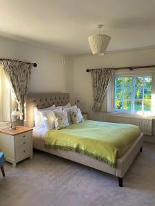 um quarto com uma cama grande e uma janela em Denham Mount em Buckinghamshire