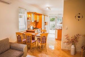 a kitchen and living room with a table and chairs at Termálfürdő Apartman Igal -130 méterre a fürdőtől in Igal