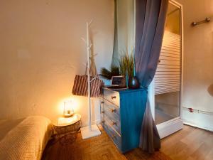 a bedroom with a blue dresser and a mirror at Casa Doutre in Angers