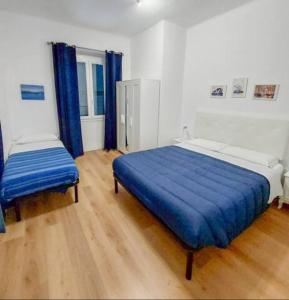 a bedroom with a large blue bed and a window at Il mare in valigia in Imperia