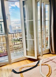 a room with windows with a view of a balcony at Chambre avec terrasse à Montmartre Sacré Coeur in Paris