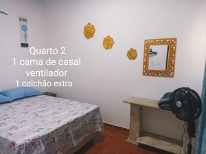een slaapkamer met een bed en een spiegel aan de muur bij Casa para 12 pessoas perto da Basílica e da Feira in Aparecida