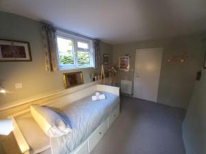 a bedroom with a bed and a window at Truly Paradise Cottage in Golant +24 photos