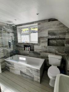 a bathroom with a toilet and a bath tub at Truly Paradise Cottage in Golant