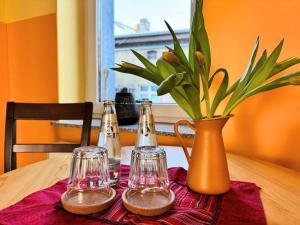 a table with two glasses and a vase on it at Pension am Plan in Herzberg