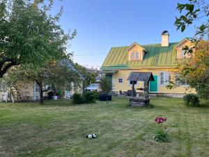 a house with a green roof and a yard at Haapsalu Posti in Haapsalu