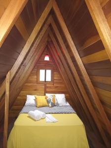 a bed in a room in a wooden attic at Recanto Quina da Mata in Santo Antônio do Pinhal