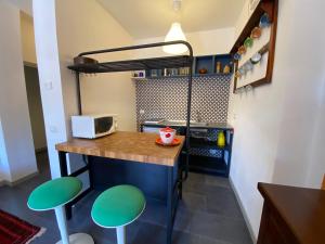 una pequeña cocina con mesa y 2 taburetes verdes en Casa Silvia, en Abetone