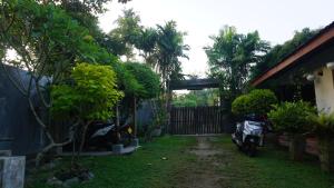 a yard with a motorcycle parked next to a house at The Whitegates Lodge in Weligama