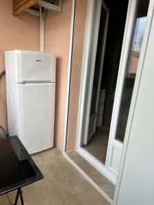 - un réfrigérateur blanc installé dans une pièce à côté d'une porte dans l'établissement studio climatisé proche port et plages, à La Londe-les-Maures