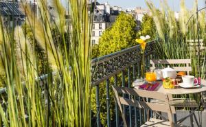 une table et des chaises sur un balcon avec vue dans l'établissement Chambre proche Elysée, à Paris