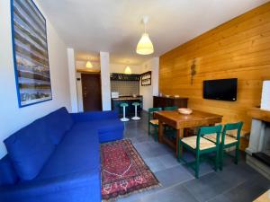 a living room with a blue couch and a wooden wall at Casa Silvia in Abetone