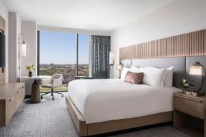 ein Hotelzimmer mit einem großen Bett und einem Schreibtisch in der Unterkunft Loews Arlington Hotel in Arlington