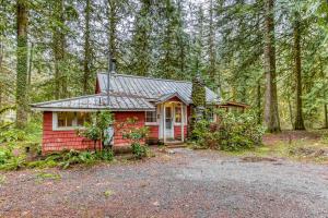 a red house in the middle of the forest at The Cedars Cabin in Welches