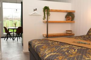 1 dormitorio con 1 cama y comedor con mesa en Het Groeneveld, en Oudkarspel