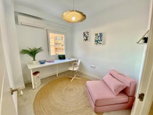 a room with a desk and a pink chair at Amplio apartamento en el centro de Málaga in Málaga