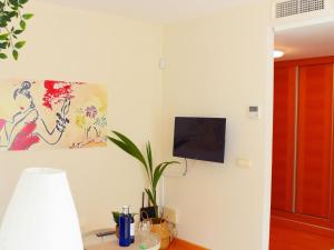 Cozy apatment just 10 mins from the City Centre في مالقة: غرفة معيشة مع تلفزيون على الحائط